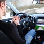 Man in a self-driving car, no hands on the steering wheel