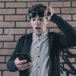 Shocked man looking at phone